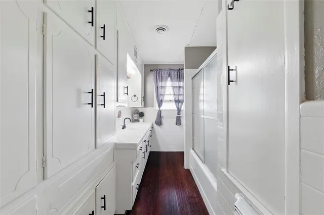 a view of a hallway with a white walls and wooden floor