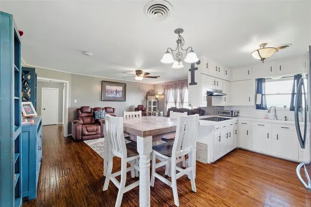 a large kitchen with cabinets a sink a center island and stainless steel appliances