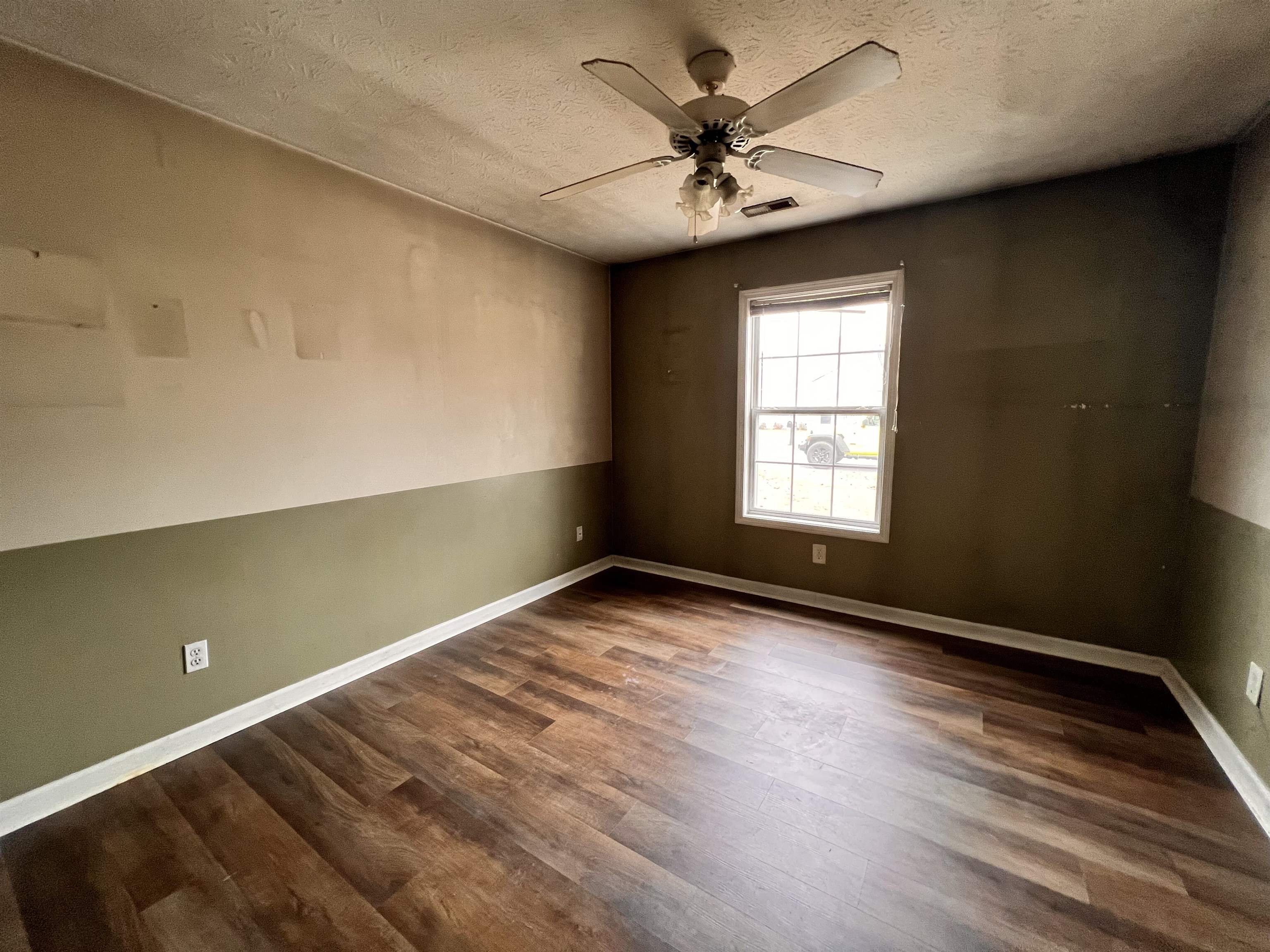 4027 Douglas Fir Lane Murrells Inlet, SC 29576 - Photo 11 of 22 Empty room featuring dark wood finished floors, a ceiling fan, and a textured ceiling