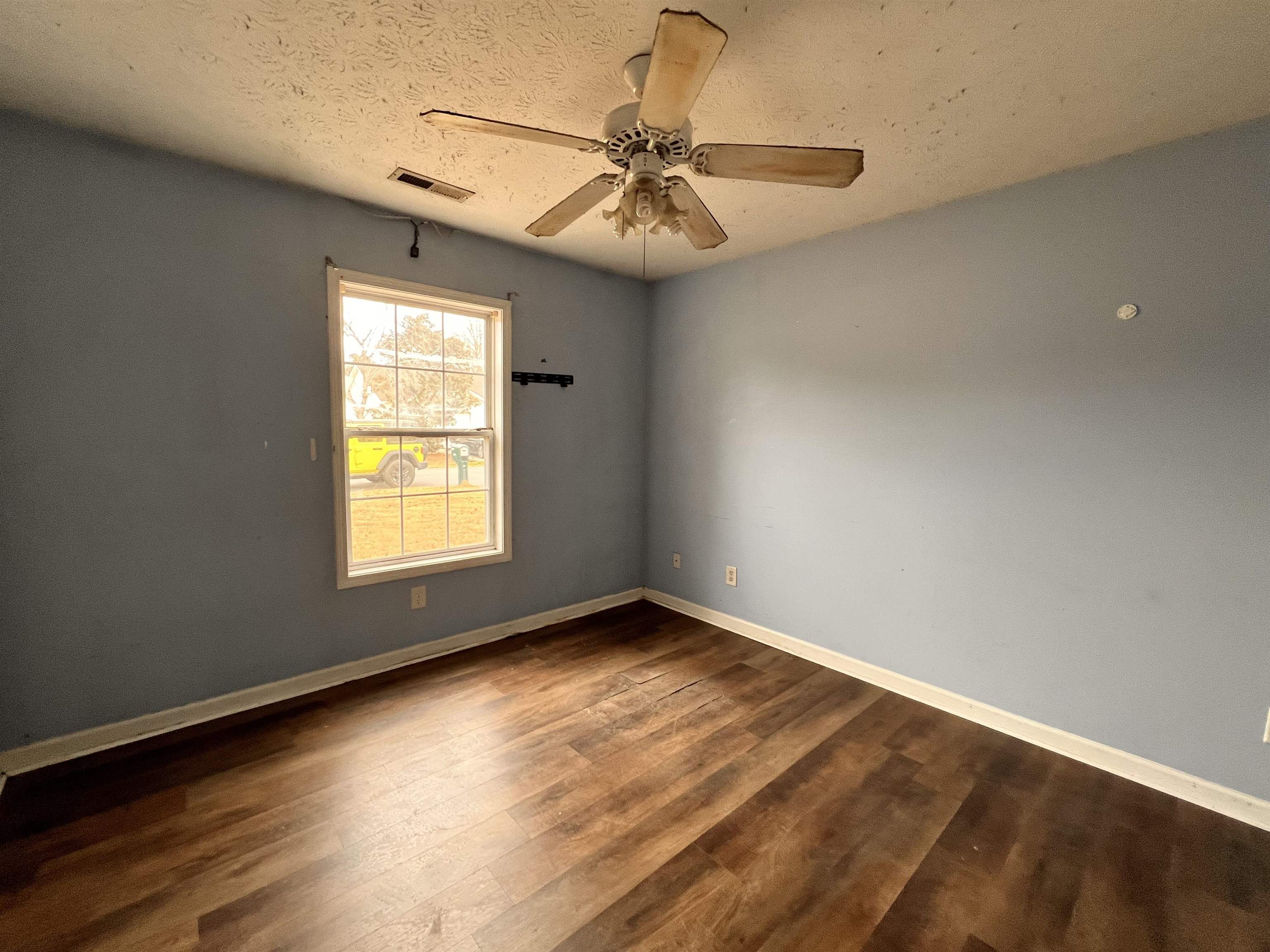4027 Douglas Fir Lane Murrells Inlet, SC 29576 - Photo 13 of 22 Spare room featuring dark wood-style flooring, a ceiling fan, and a textured ceiling