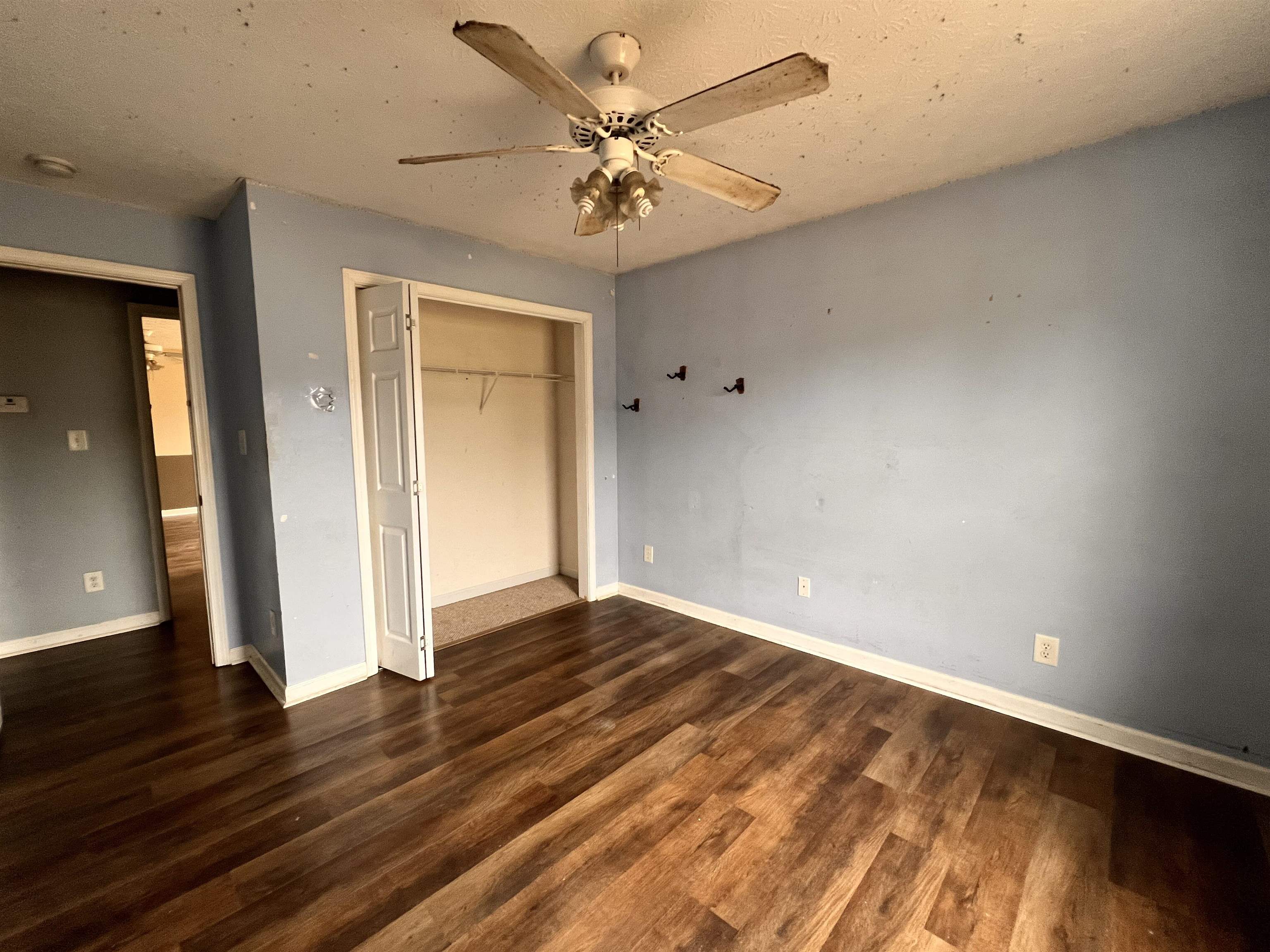 4027 Douglas Fir Lane Murrells Inlet, SC 29576 - Photo 14 of 22 Unfurnished bedroom with a closet, ceiling fan, dark wood-style flooring, and a textured ceiling