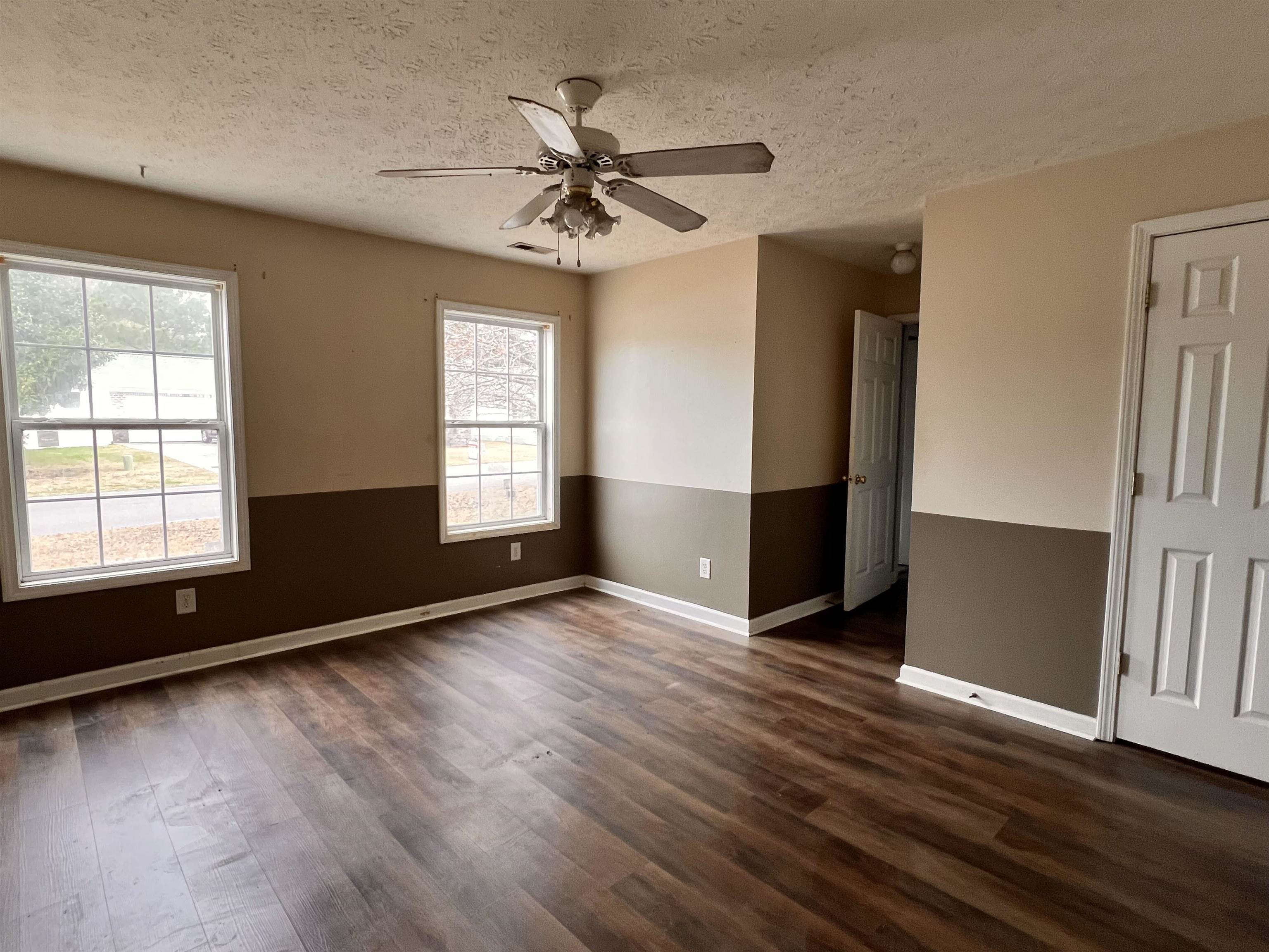 4027 Douglas Fir Lane Murrells Inlet, SC 29576 - Photo 18 of 22 Spare room featuring a textured ceiling, dark wood-style flooring, a ceiling fan, and plenty of natural light