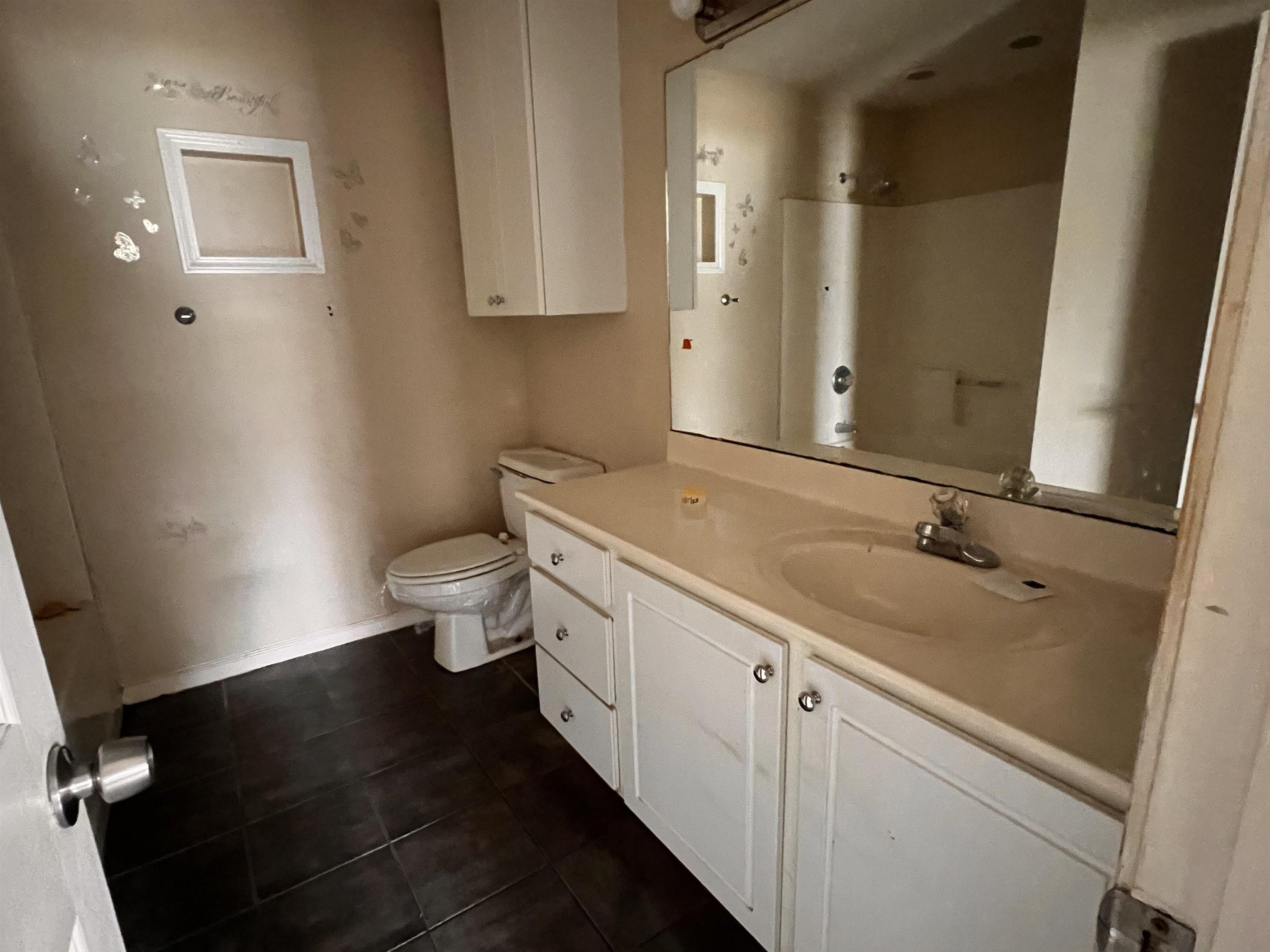 4027 Douglas Fir Lane Murrells Inlet, SC 29576 - Photo 19 of 22 Bathroom with vanity, dark tile patterned floors, and a shower