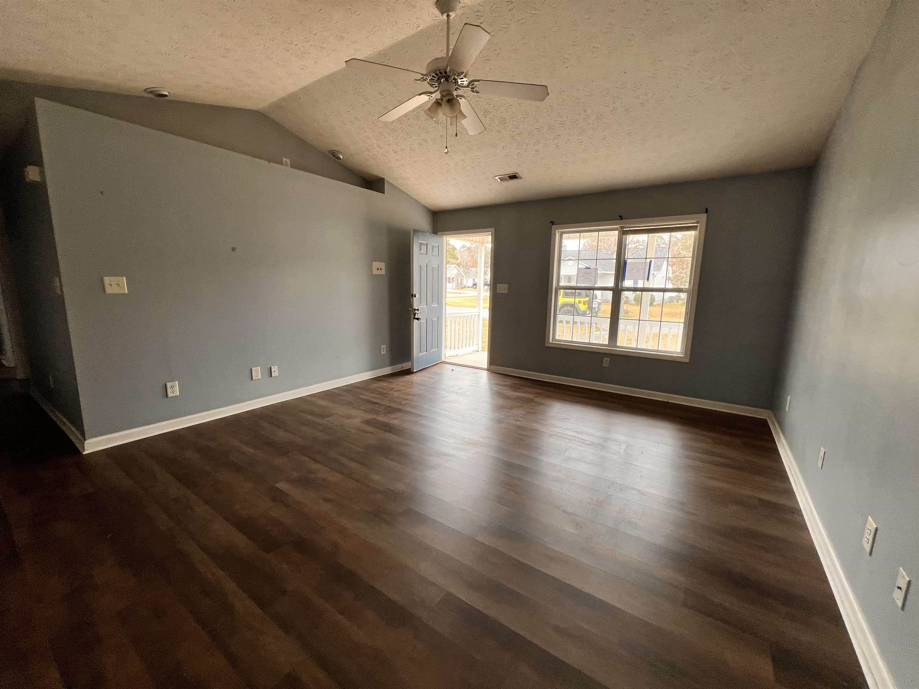 4027 Douglas Fir Lane Murrells Inlet, SC 29576 - Photo 3 of 22 Spare room with dark wood finished floors, a textured ceiling, lofted ceiling, and a ceiling fan