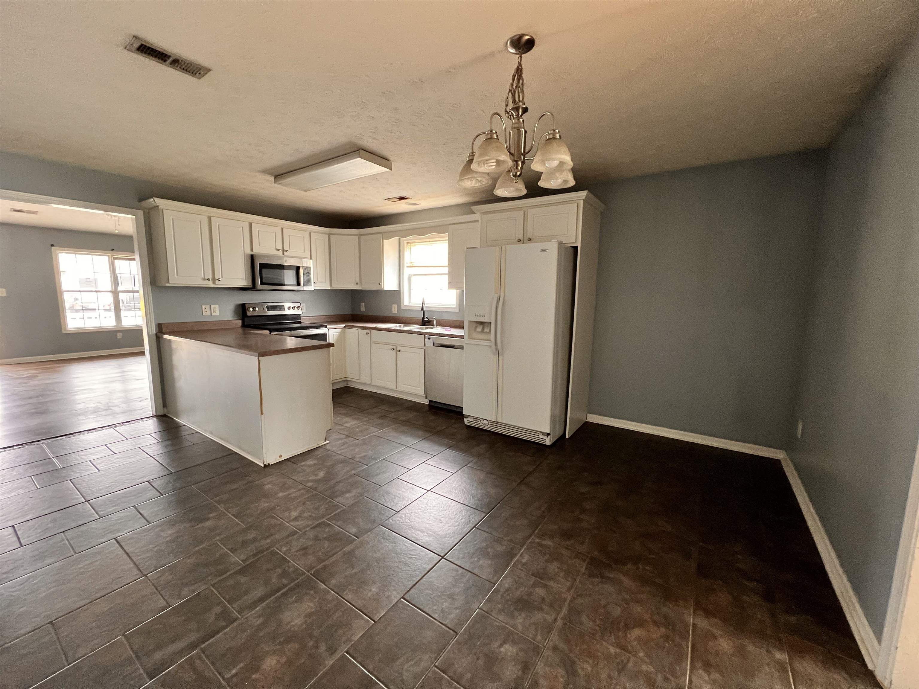 4027 Douglas Fir Lane Murrells Inlet, SC 29576 - Photo 5 of 22 Kitchen featuring white cabinetry, appliances with stainless steel finishes, dark countertops, a chandelier, and decorative light fixtures
