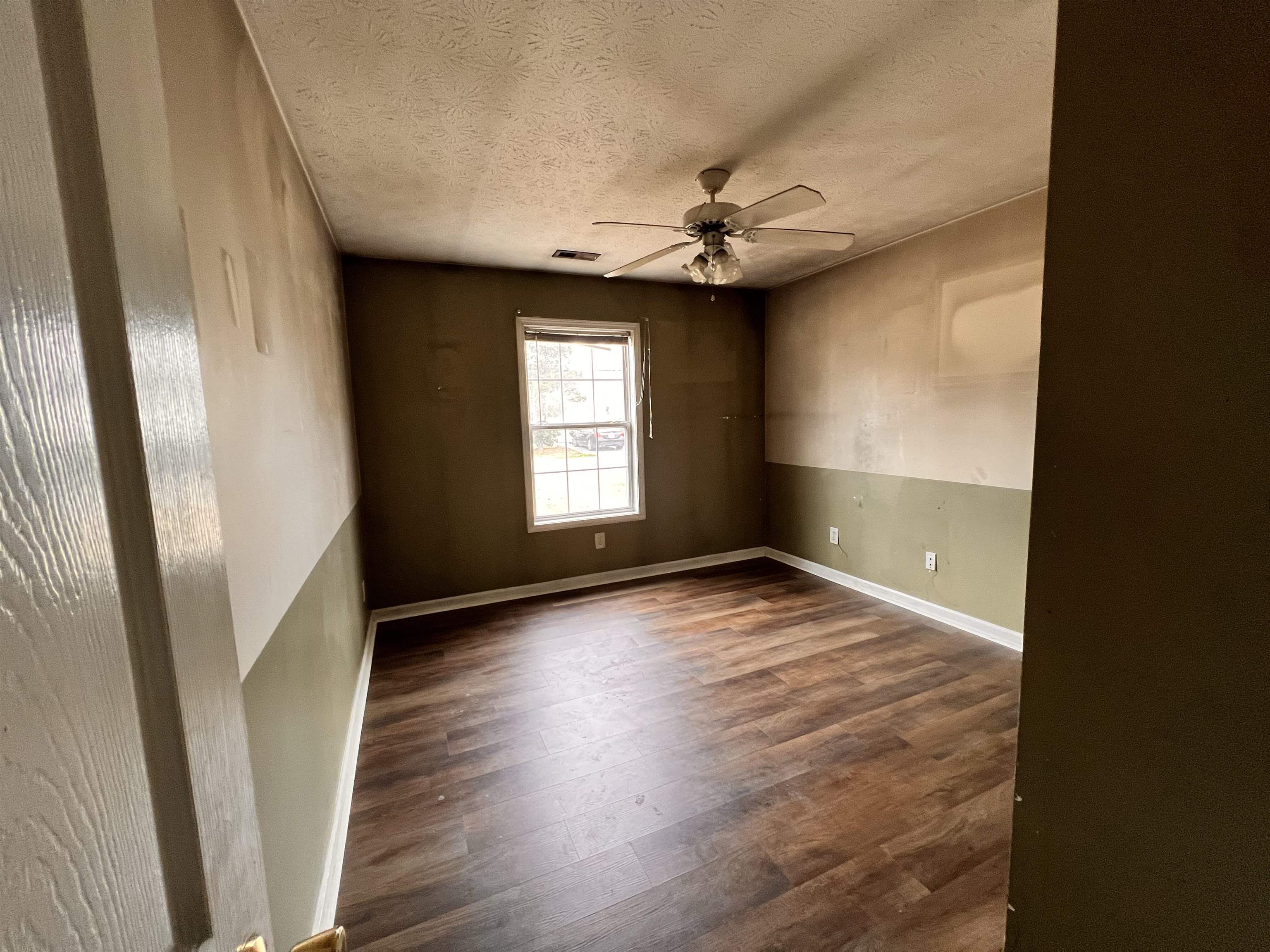 4027 Douglas Fir Lane Murrells Inlet, SC 29576 - Photo 9 of 22 Empty room featuring dark wood-type flooring, ceiling fan, and a textured ceiling