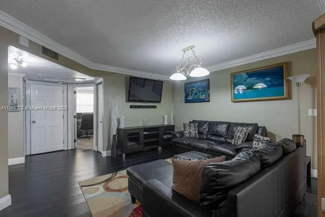 a living room with furniture chandelier and a flat screen tv