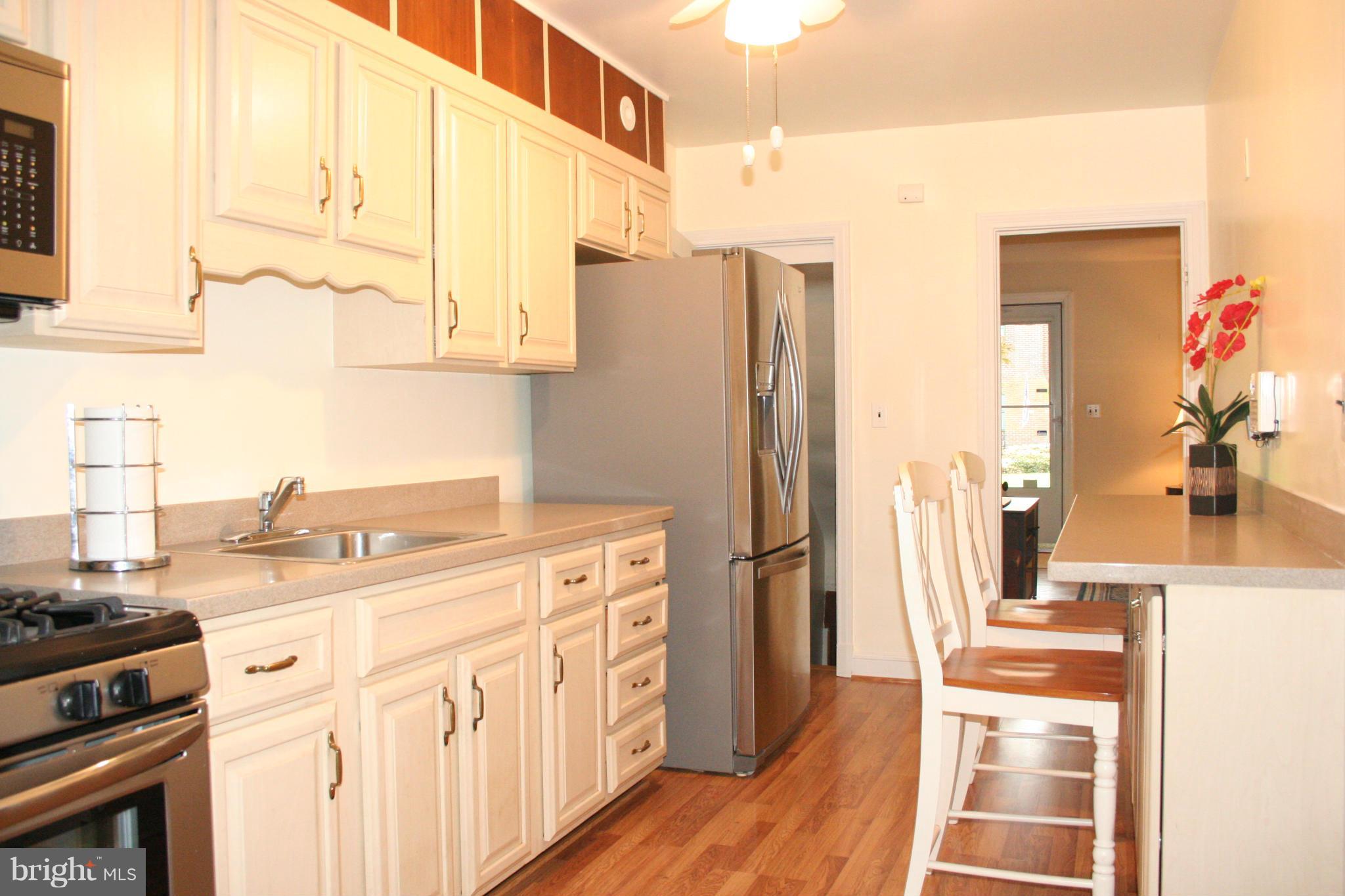216 Dunkirk Road Baltimore, MD 21212 - Photo 6 of 21 a kitchen with stainless steel appliances granite countertop a refrigerator and a stove top oven