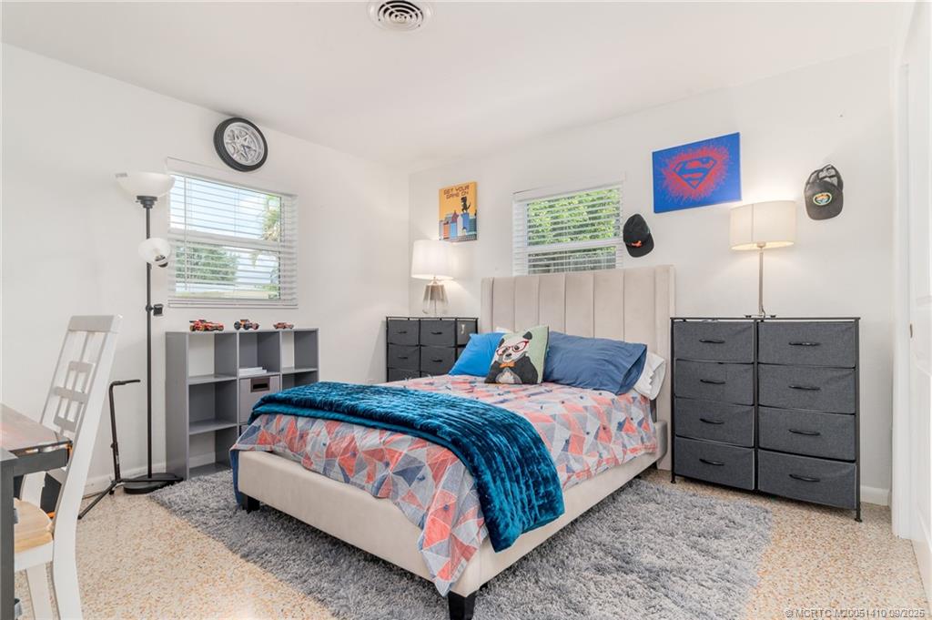 2859 Northeast Hickory Ridge Avenue Jensen Beach, FL 34957 - Photo 20 of 32 a bedroom with a bed and a window