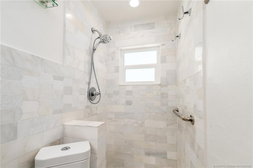 2859 Northeast Hickory Ridge Avenue Jensen Beach, FL 34957 - Photo 8 of 32 a bathroom with a shower