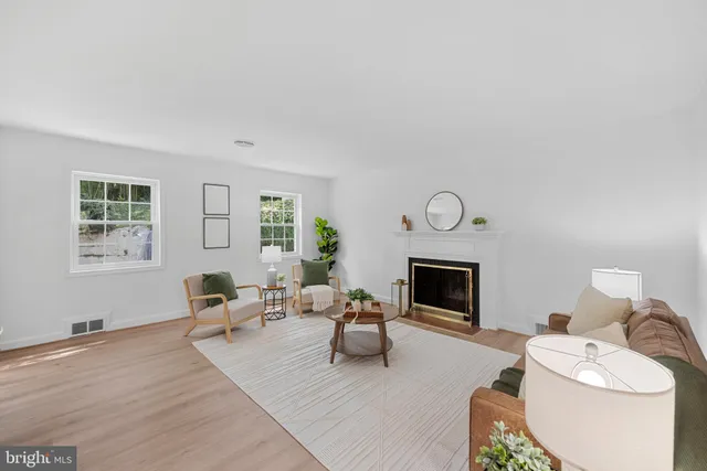 a living room with furniture a fireplace and a window