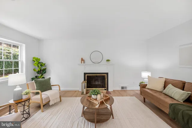 a living room with furniture a fireplace and a window