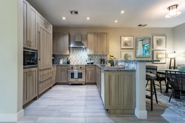 a living room with furniture a floor to ceiling window and wooden floor