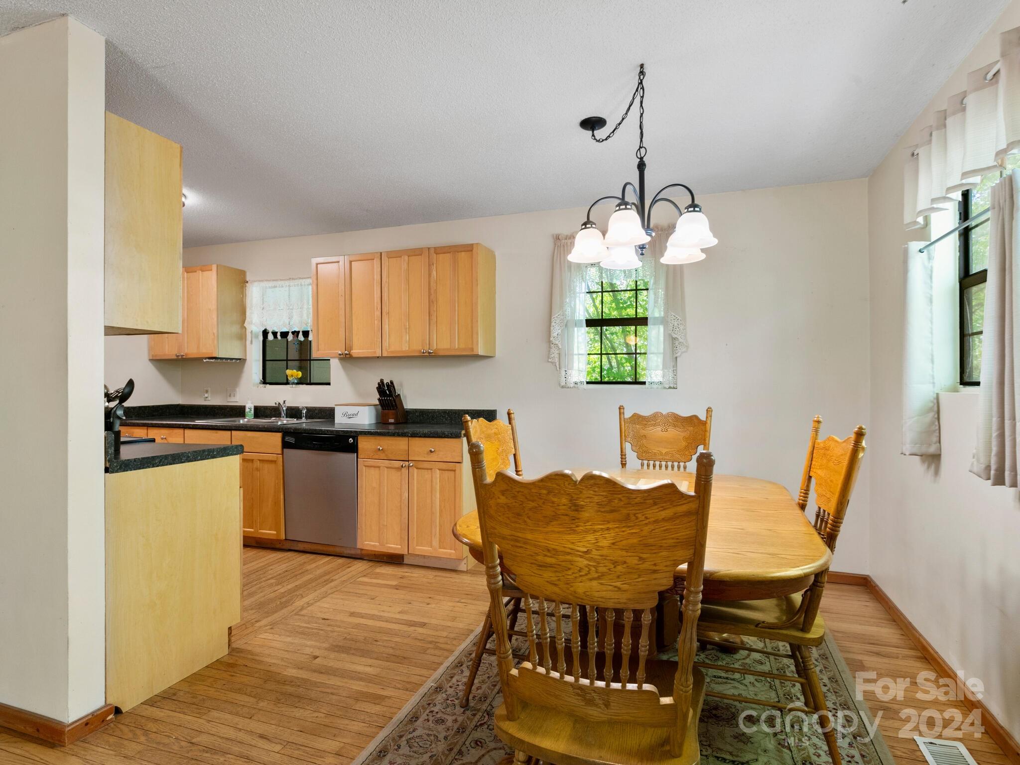 46 New Lite Road Fairview, NC 28730 - Photo 13 of 31 a kitchen with granite countertop a stove a sink dishwasher a dining table and chairs with wooden floor