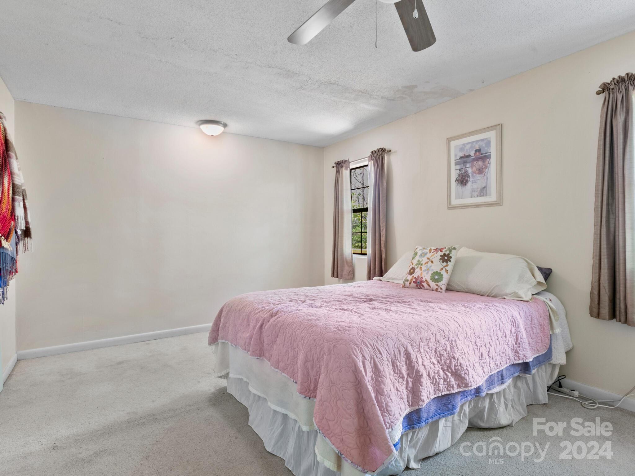 46 New Lite Road Fairview, NC 28730 - Photo 21 of 31 a bedroom with a bed and painting on the wall