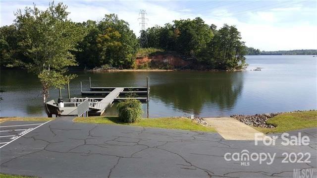 151 Pier Point Drive, Unit 9 Stony Point, NC 28678 - Photo 16 of 18 a view of a lake with a bench under large trees