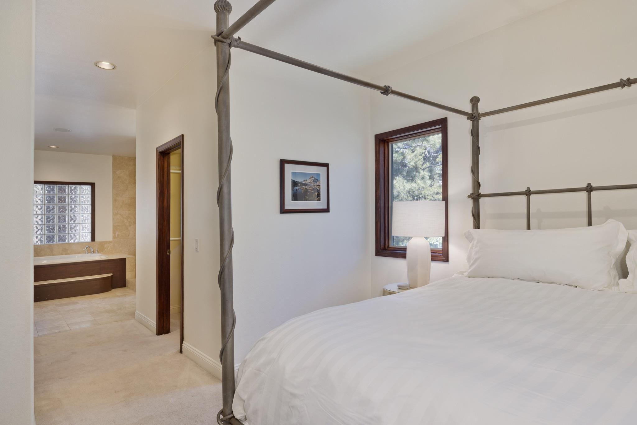378 Ridge Way Mammoth Lakes, CA 93546 - Photo 23 of 43 Bedroom featuring a dark wood framed window, recessed lighting, and an adjacent bathroom with a glass block window and built-in tub surround