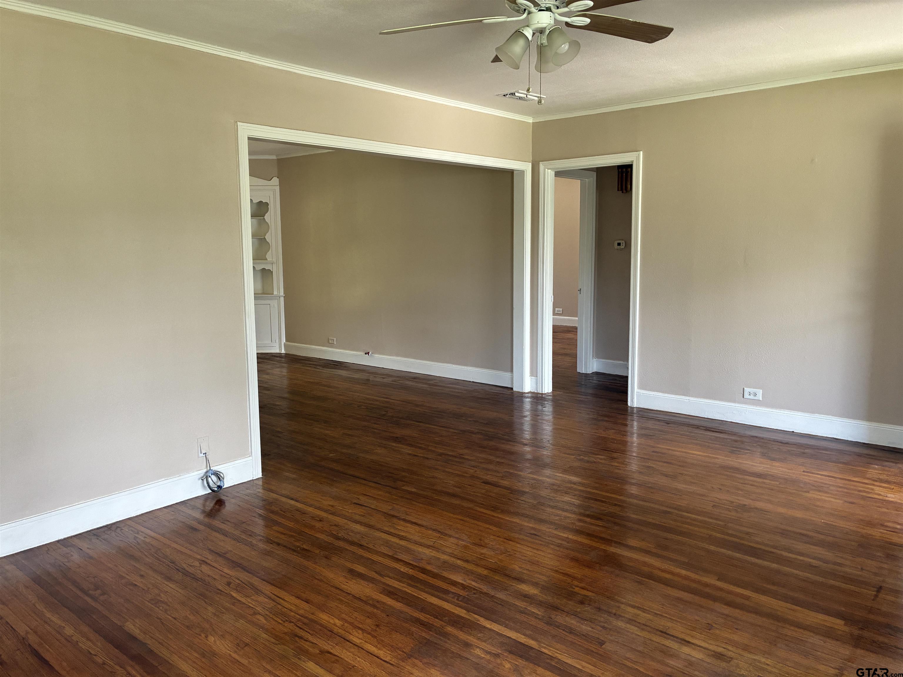 811 West 5th Street Tyler, TX 75701 - Photo 5 of 26 an empty room with wooden floor and fan