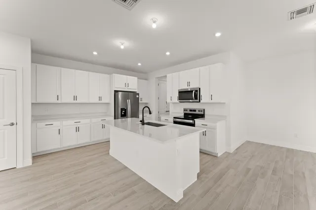 a kitchen with white cabinets and stainless steel appliances