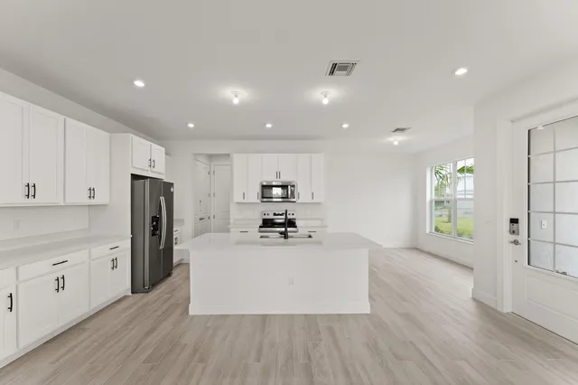 a kitchen with stainless steel appliances a refrigerator and a stove top oven