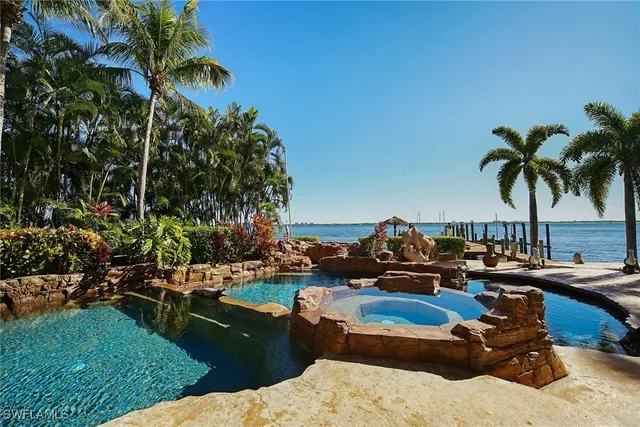 a blue swimming pool with lawn chairs and a fire pit