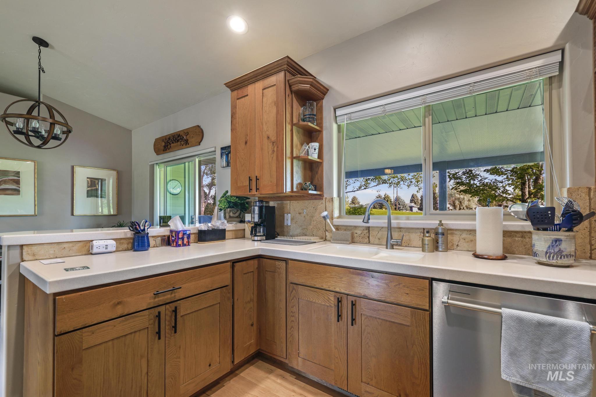 100 Olympic Road Jerome, ID 83338 - Photo 15 of 50 Kitchen with wood-finish cabinetry, light-toned countertops, and a tile backsplash