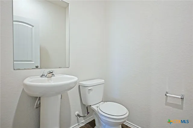 a bathroom with a sink a toilet and mirror