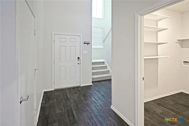a view of a hallway with wooden floor and entryway