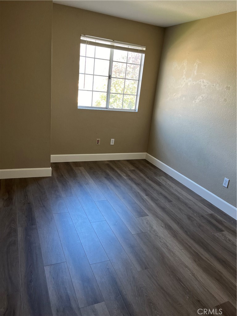 33033 Tulley Ranch Road Temecula, CA 92592 - Photo 8 of 14 an empty room with wooden floor and windows