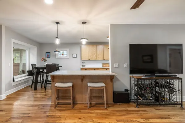 a living room with furniture a flat screen tv and kitchen view