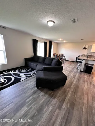 a living room with furniture and a wooden floor