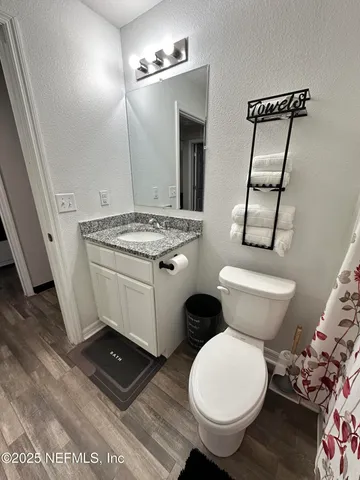 a bathroom with a granite countertop toilet sink and mirror