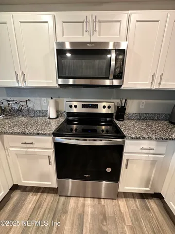 a kitchen with stainless steel appliances a stove a microwave a sink and cabinets