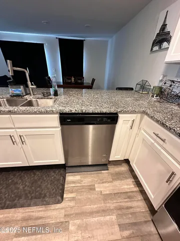 a view of kitchen with stainless steel appliances granite countertop sink stove and granite counter top