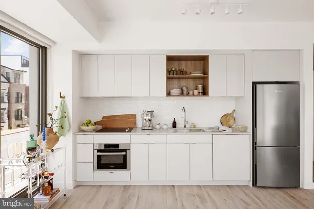 a kitchen with stainless steel appliances a stove a refrigerator and a sink