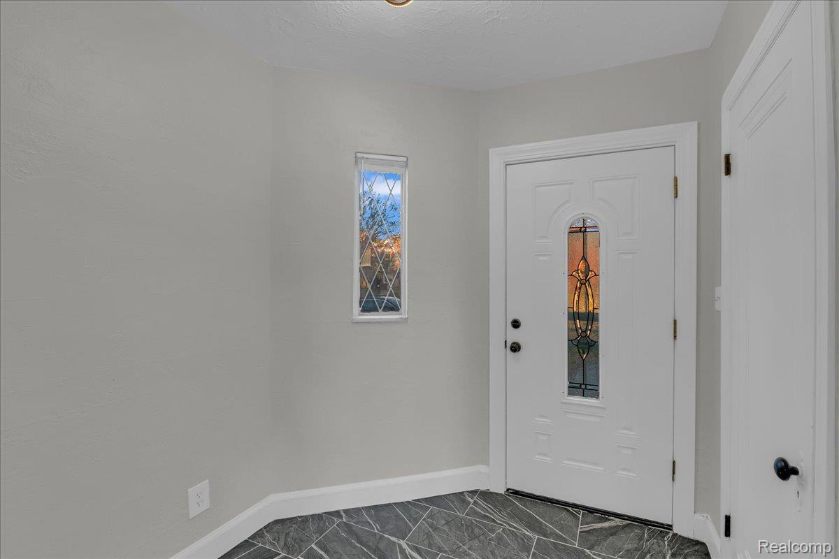 16717 Fielding Street Detroit, MI 48219 - Photo 4 of 46 Foyer entrance featuring baseboards and dark marble finish floors