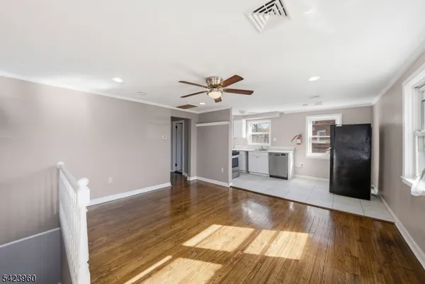 a view of a living room a refrigerator and wooden floor
