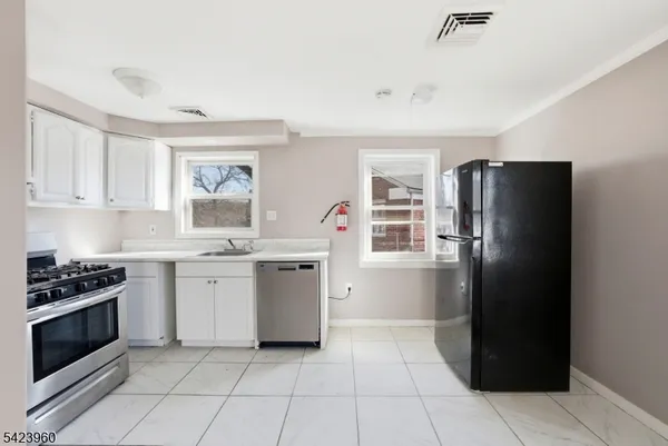 a kitchen with a refrigerator and a stove top oven