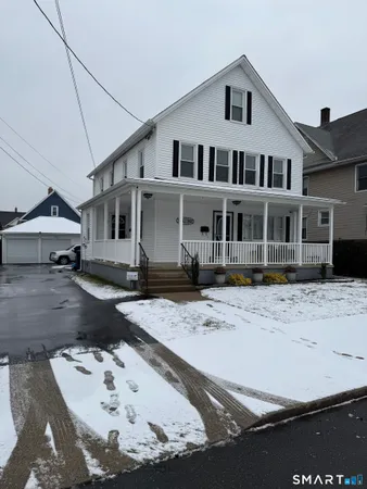 a view of a white house with a yard in the background