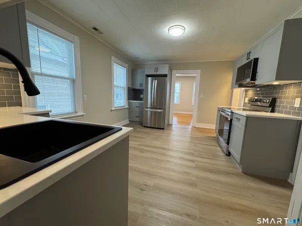 a kitchen with stainless steel appliances granite countertop a sink and a refrigerator