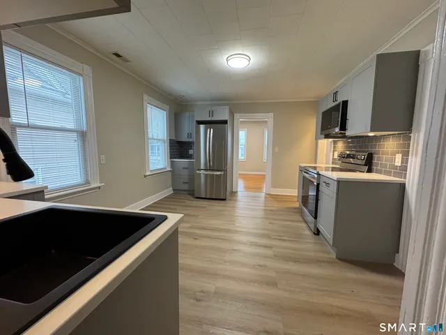 a kitchen with stainless steel appliances granite countertop a sink and a stove
