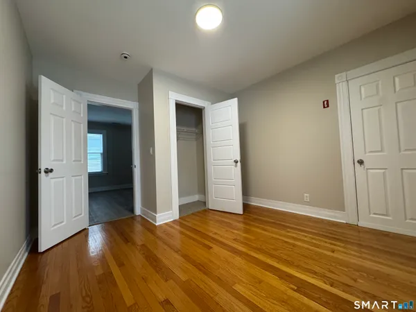 an empty room with wooden floor and closet