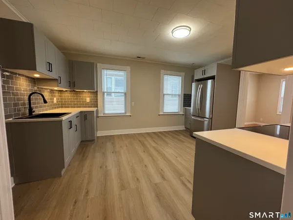 a kitchen with stainless steel appliances granite countertop a sink a stove and refrigerator