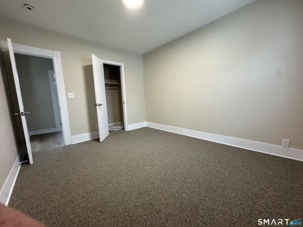 an empty room with closet and mirror