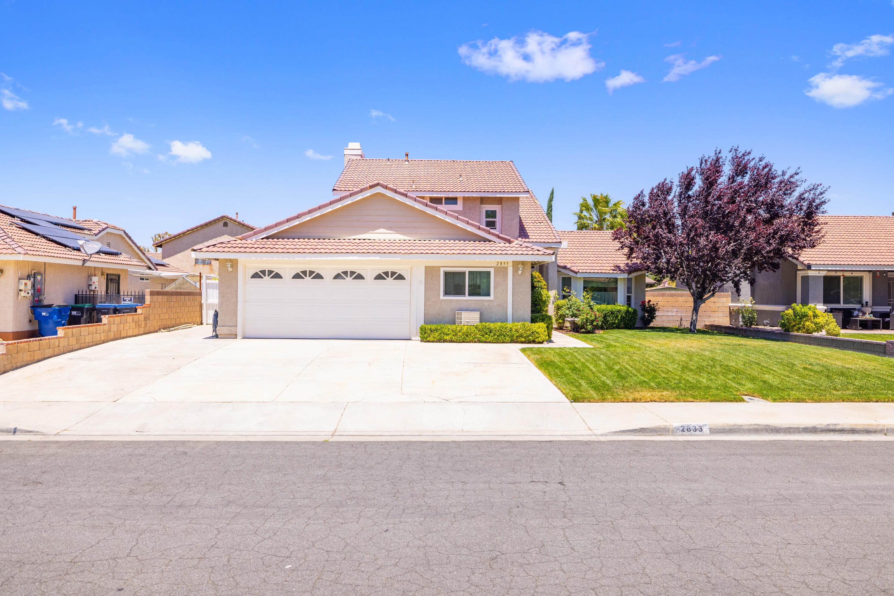 2833 Springfield Place Lancaster, CA 93536 - Photo 1 of 37 a front view of a house with a yard and garage