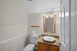 a bathroom with a granite countertop sink toilet and mirror