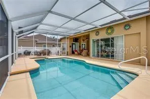 a swimming pool with outdoor seating and a tub
