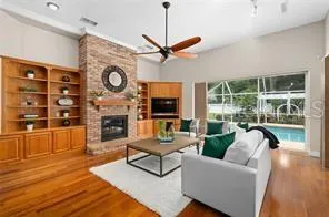 a living room with furniture a fireplace and a floor to ceiling window