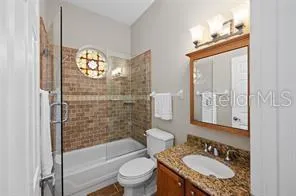 a bathroom with a granite countertop sink toilet a mirror and shower