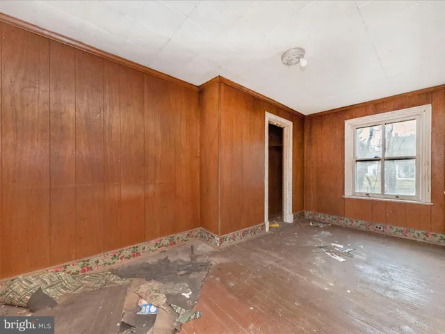a view of an empty room with window and closet area